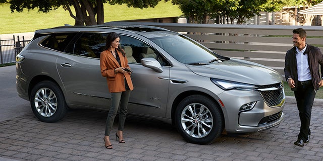 Woman and man near a 2024 Buick Enclave