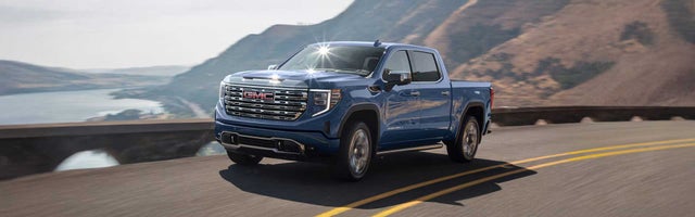 GMC Sierra 1500 driving on a coastal road over a bridge